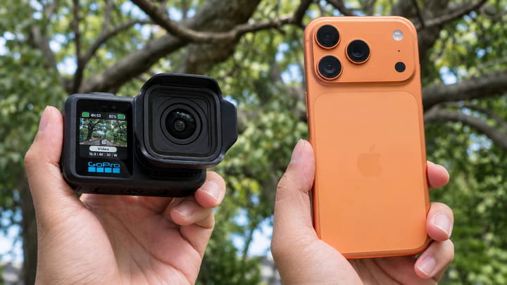 GoPro екшн-камера та iPhone поруч у руках, порівняння розмірів двох пристроїв